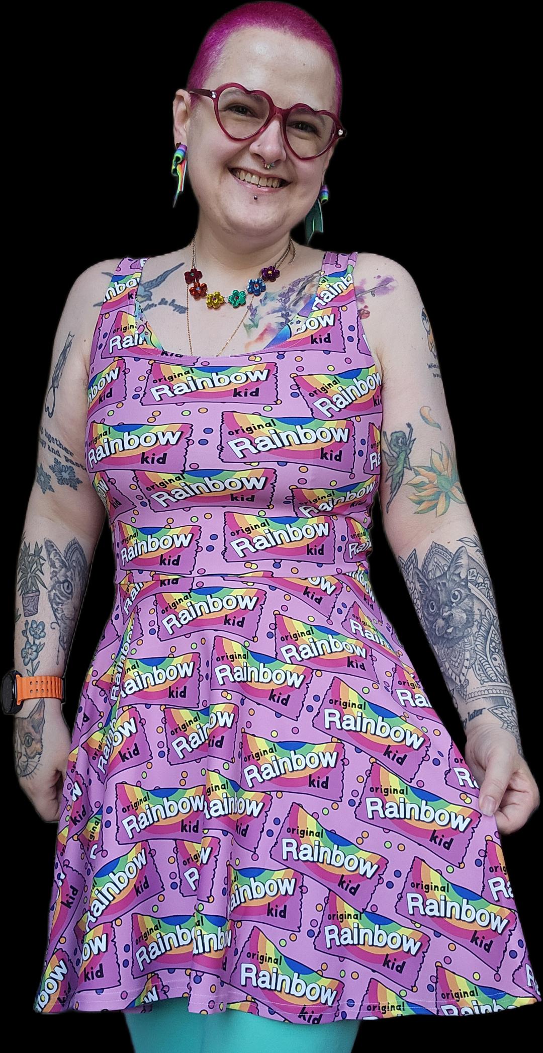 Rainbow-colored skater dress by Designed By Debz made from recycled materials, displayed on a hanger against a plain background.