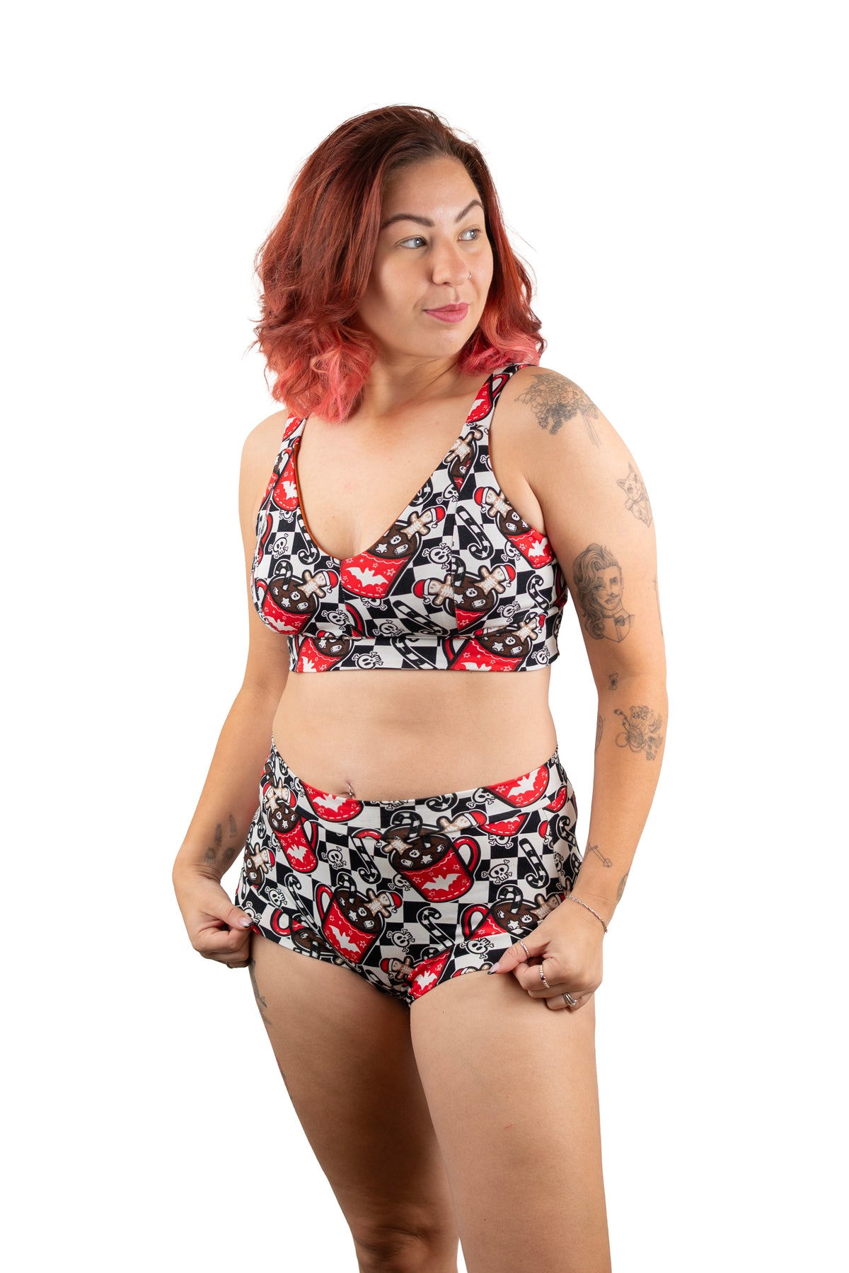 A woman modeling a two-piece bikini set with a black, white, and red lips pattern, photographed against a solid white background.