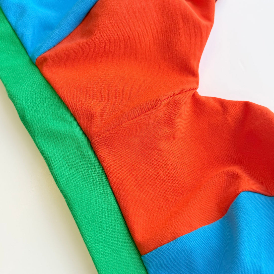 Picture of a brightly coloured bra showing a green band with elastic encased in it
