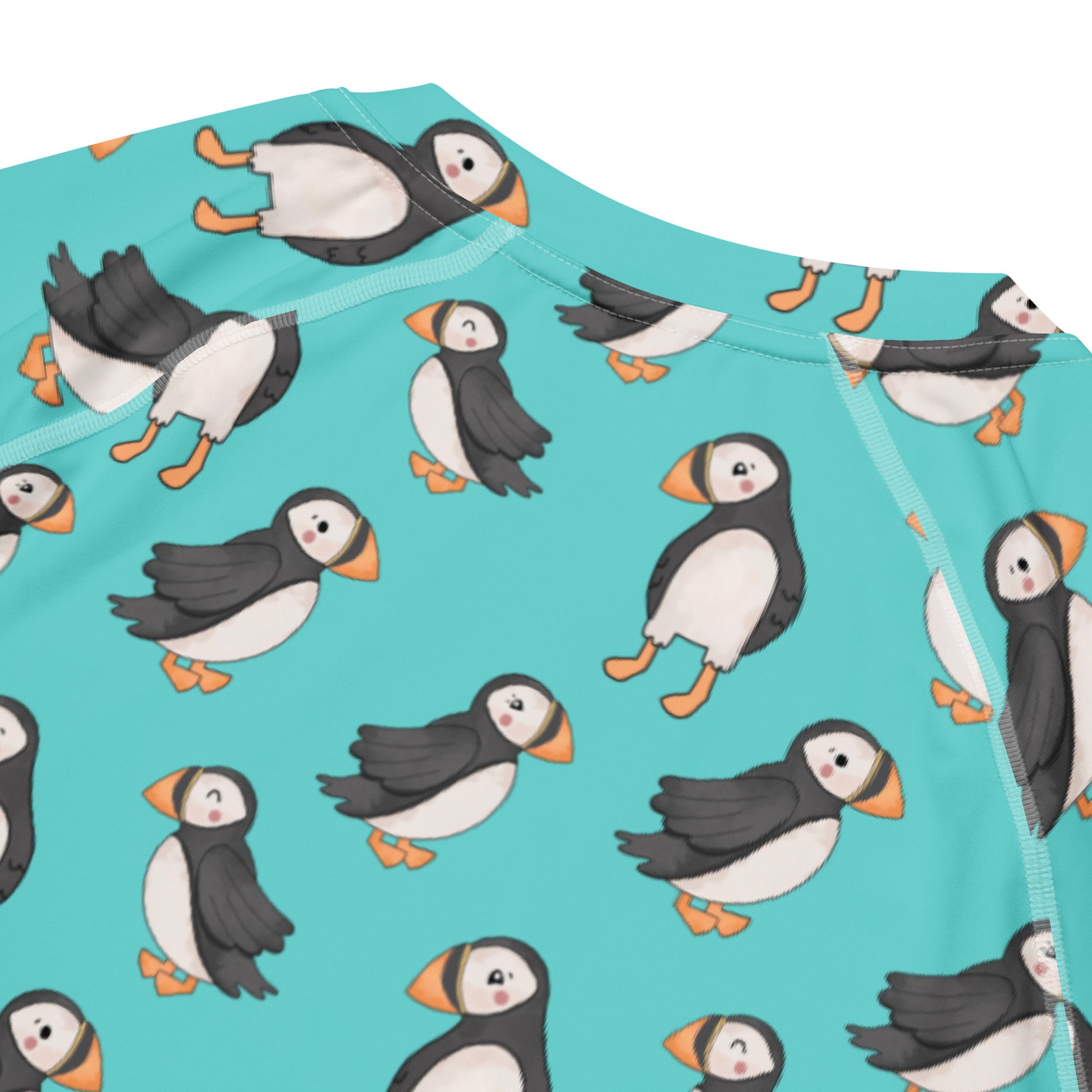 Unisex Puffin All-Over Print Short Sleeve Rash Guard by Printful featuring colorful puffin design on recycled fabric.
