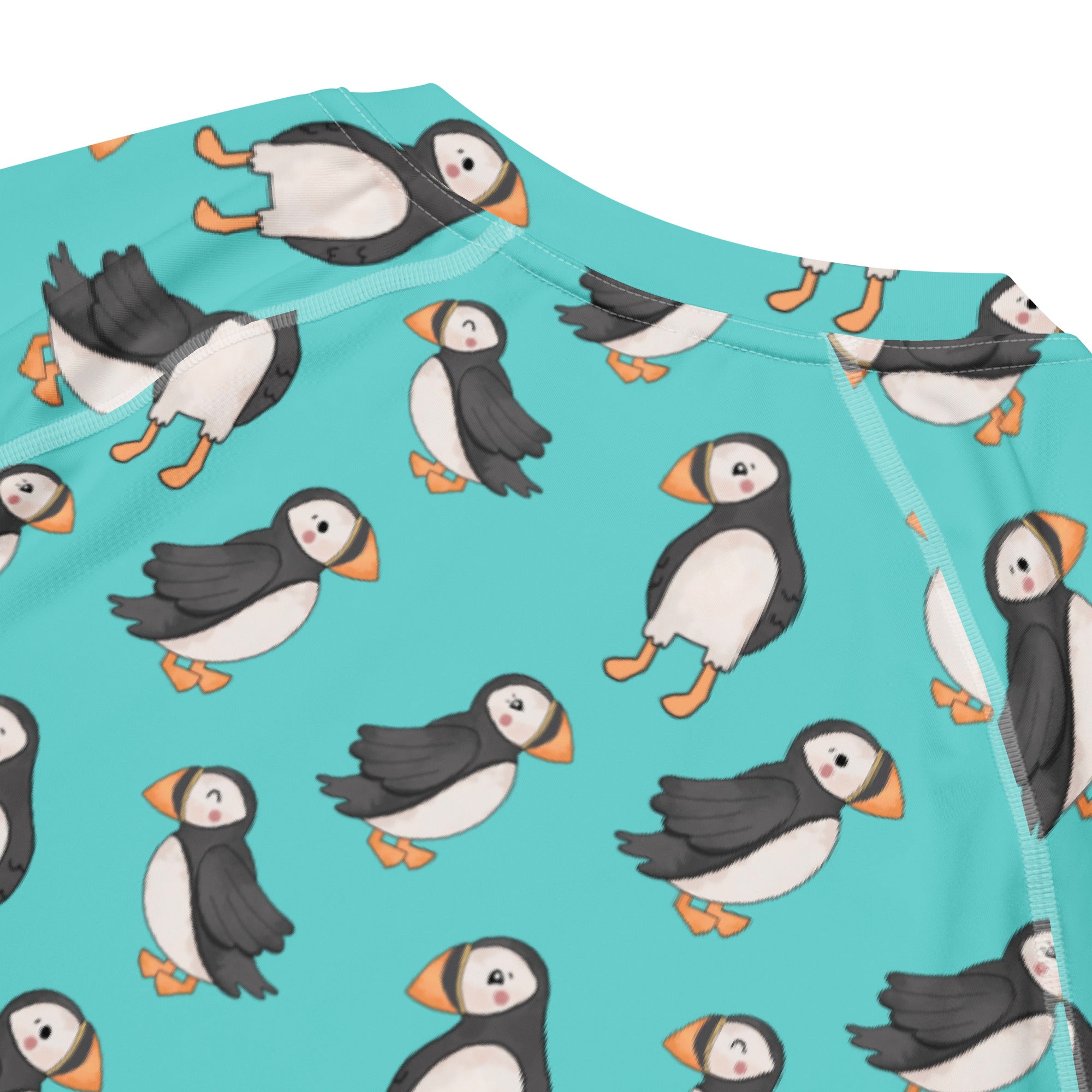 Unisex Puffin All-Over Print Short Sleeve Rash Guard by Printful featuring colorful puffin design on recycled fabric.