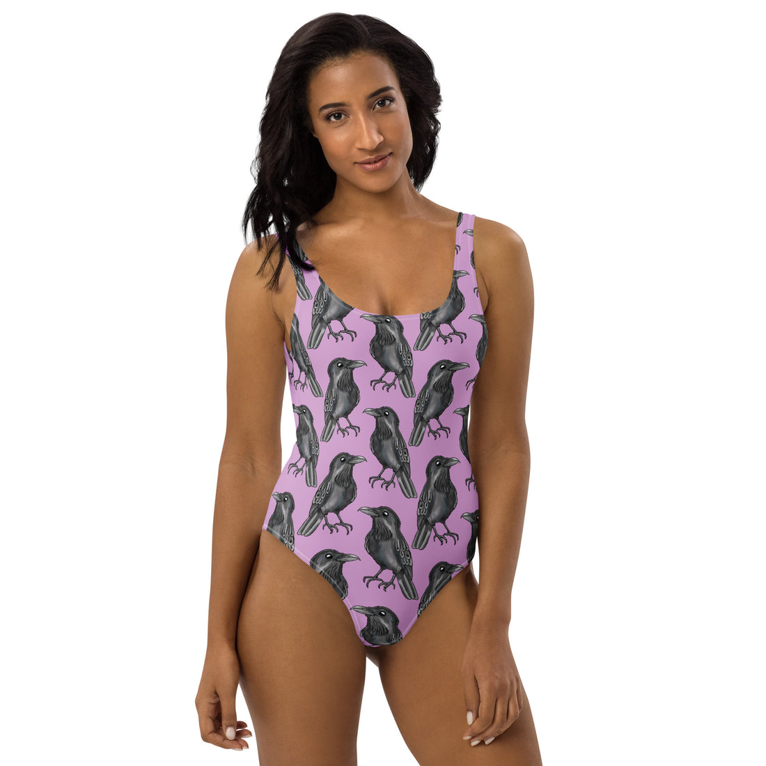 Lilac one-piece swimsuit by Printful featuring a gothic crow print and all-over black crow design on white background.