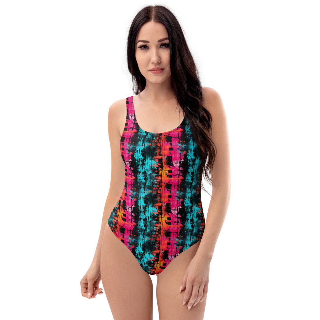 A woman modeling a one-piece swimsuit with a vibrant, multicolored abstract pattern featuring pink, teal, orange, and black vertical stripes, set against a plain white background.