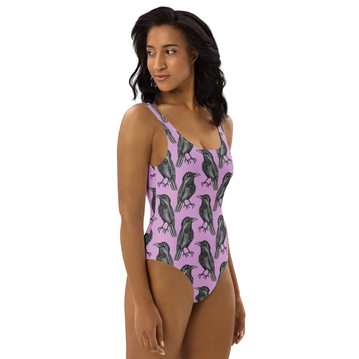 Lilac one-piece swimsuit with gothic crow print from Printful featuring an all-over crow design on a white background.
