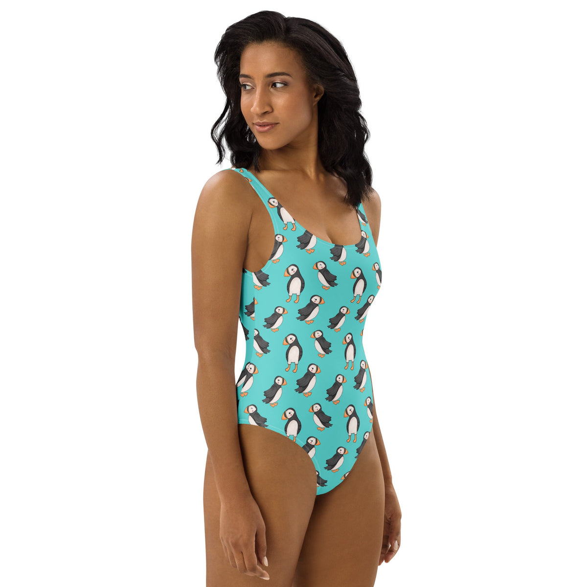 Teal one-piece swimsuit with puffin playtime print from Printful, featuring cute puffin illustrations all over the fabric.