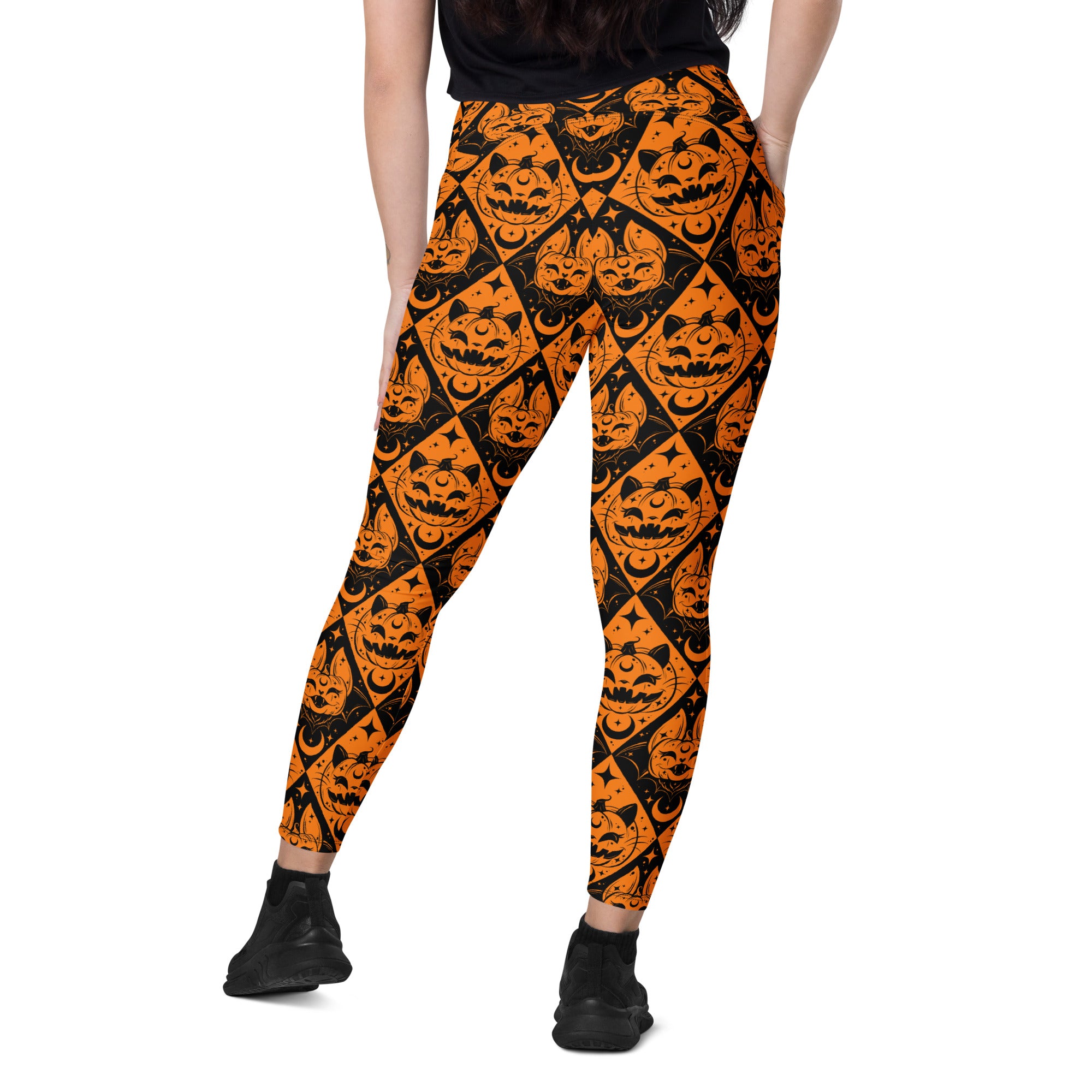 Halloween cat and pumpkin crossover leggings with pockets from Printful, featuring all-over print on white background.