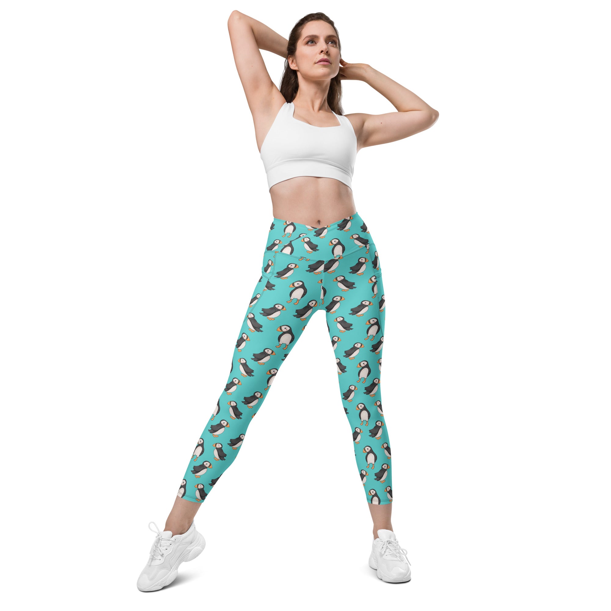 White Puffin Party crossover leggings with pockets by Printful, featuring colorful all-over bird print and comfortable stretch fabric.