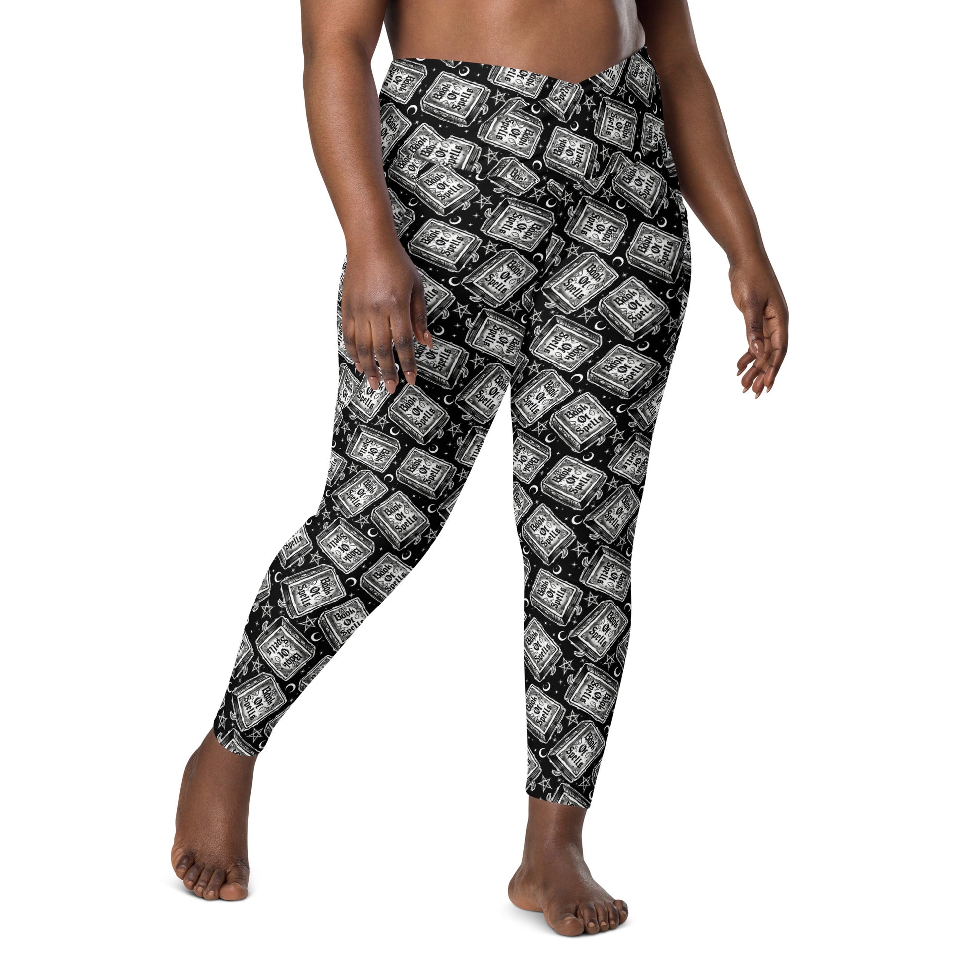 Printful Book of Spells crossover leggings with pockets, all-over white design, stretchy fabric, and comfortable fit.
