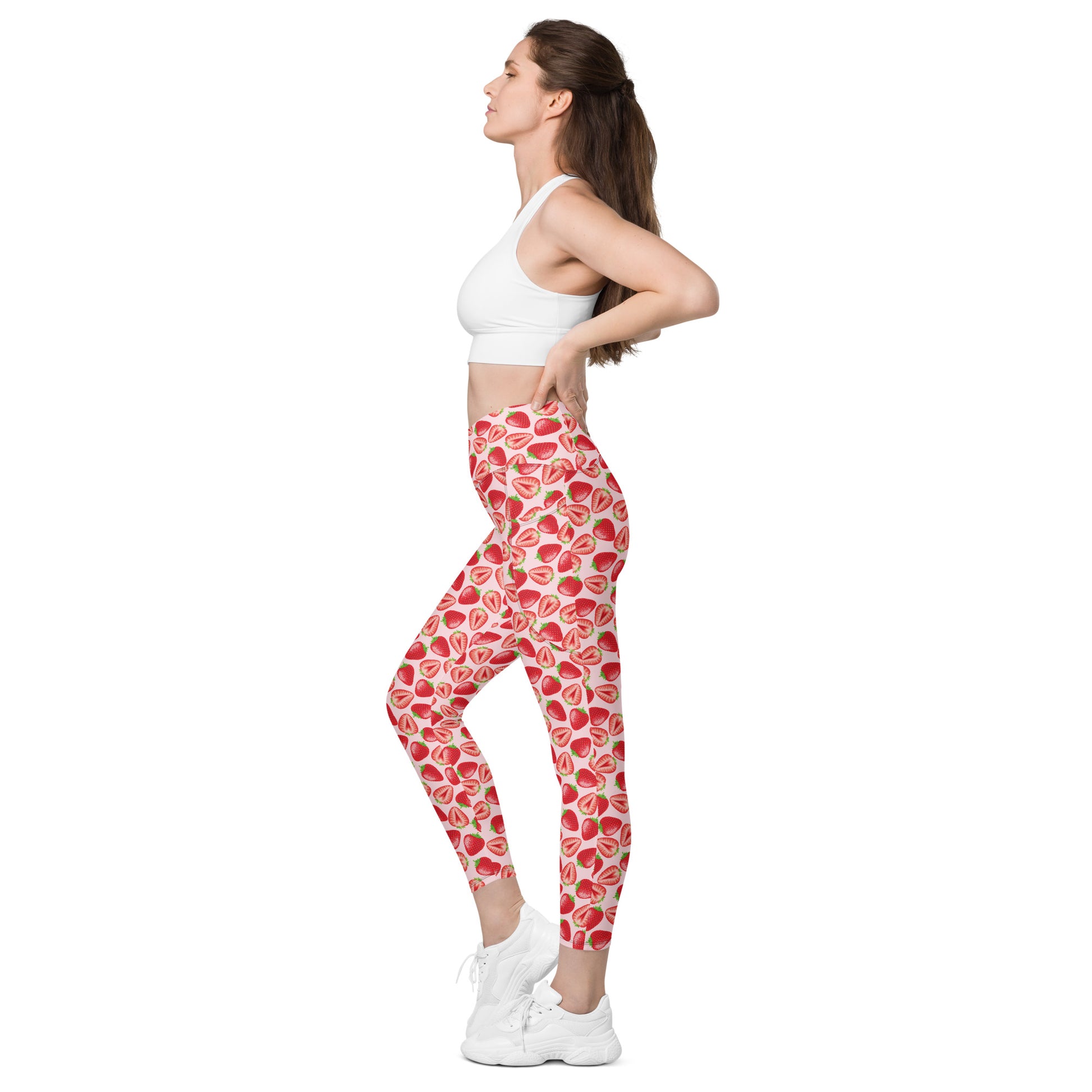 Printful crossover leggings with pockets in wild strawberry print, all-over recycled fabric, shown in white with left side view.