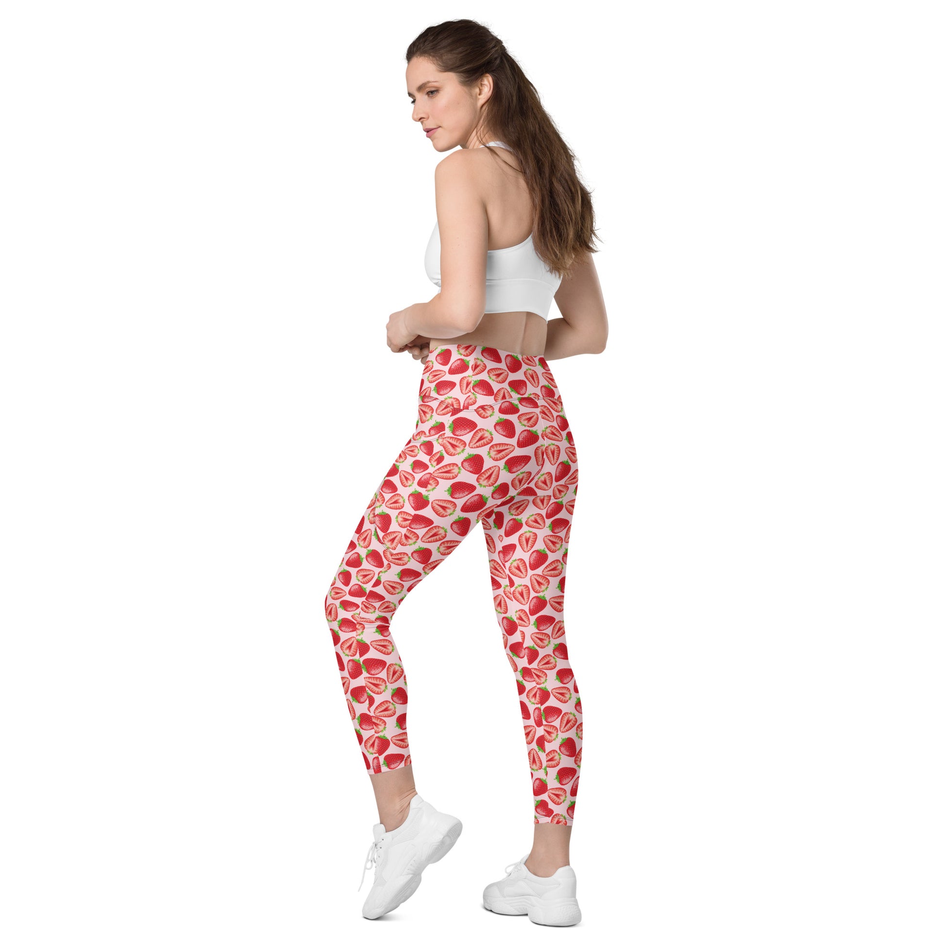 Printful crossover leggings with pockets in wild strawberry print, all-over recycled fabric, shown from back left angle.