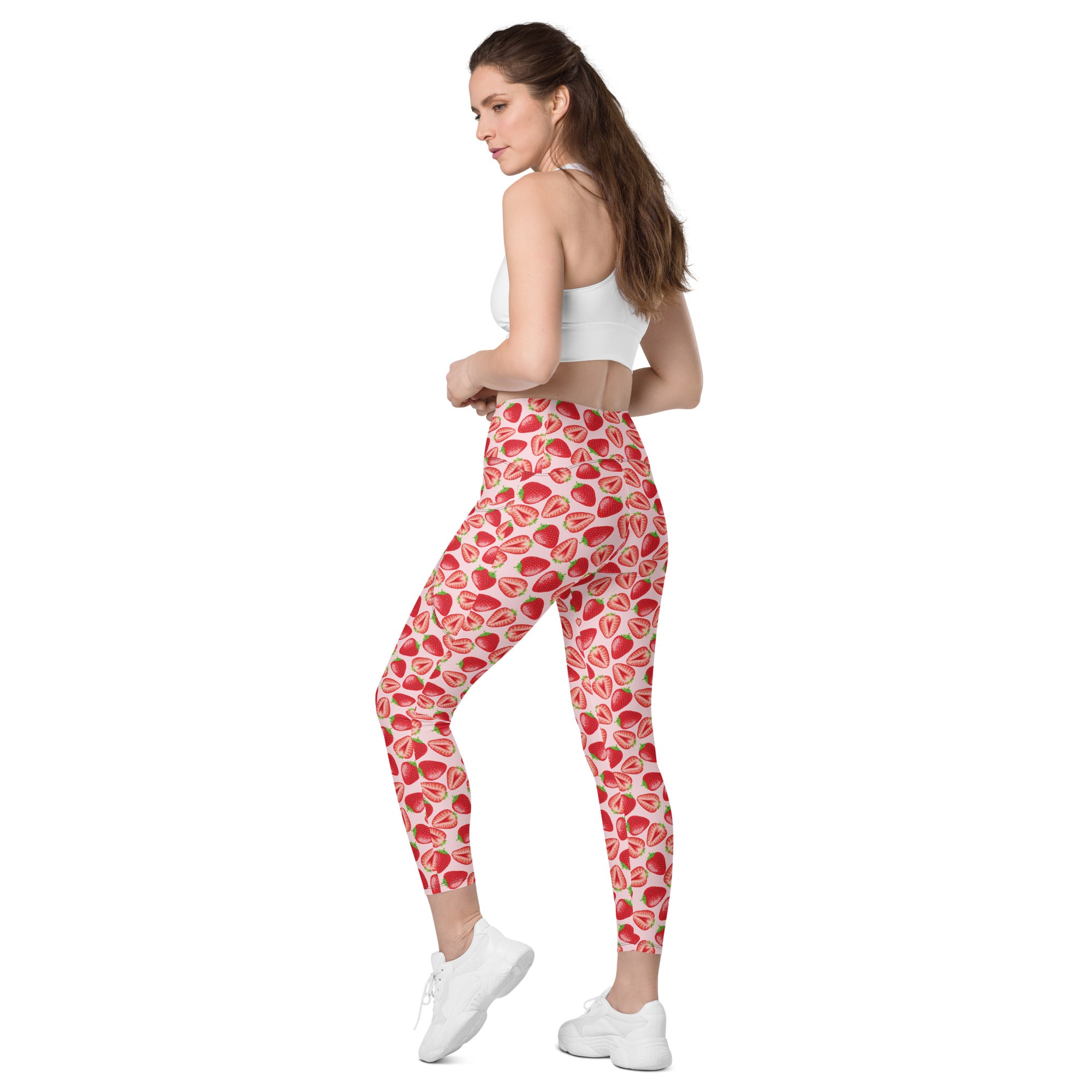 Printful crossover leggings with pockets in wild strawberry print, all-over recycled fabric, shown from back left angle.