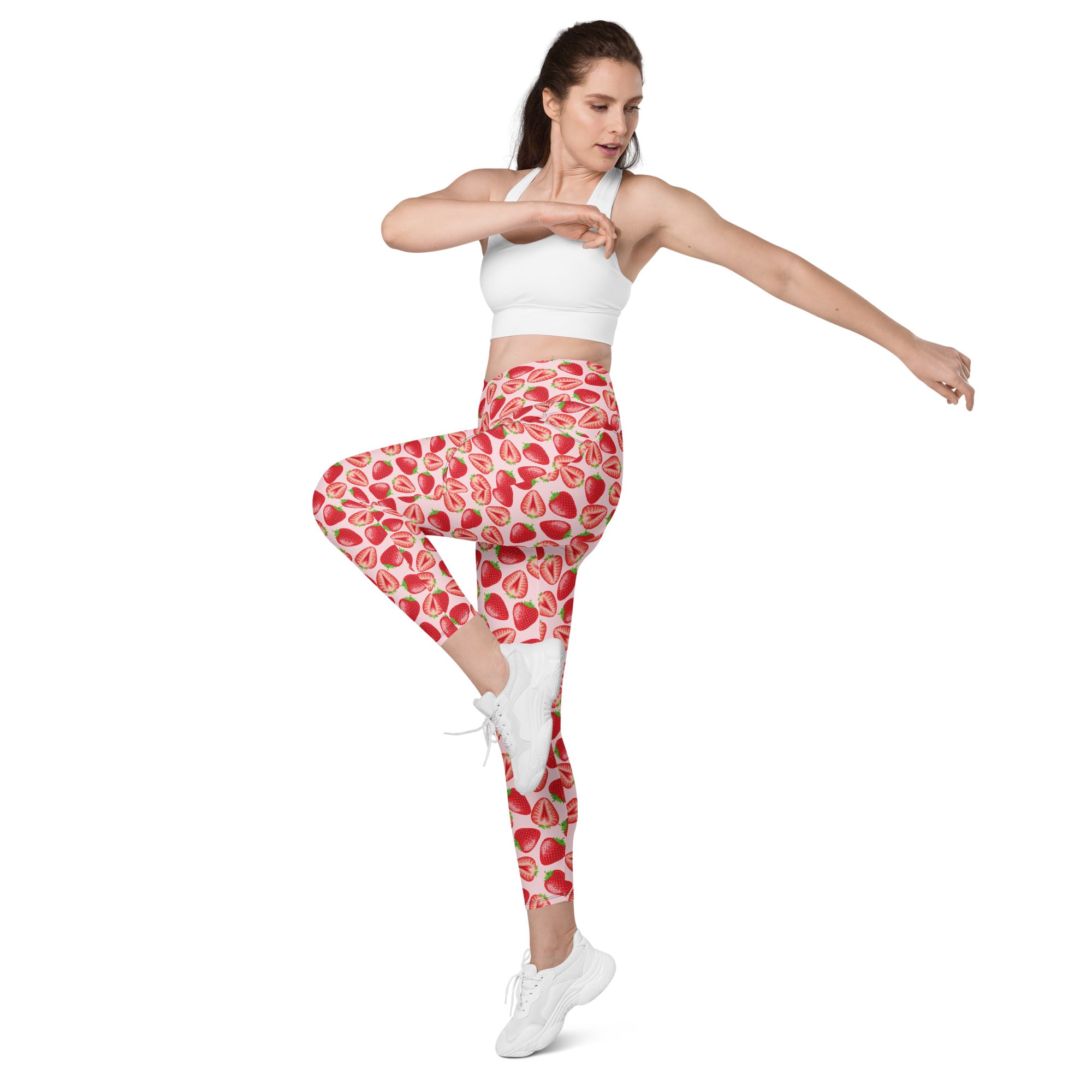 Printful crossover leggings with wild strawberry print, all-over recycled fabric, featuring pockets, worn by a model in front view.