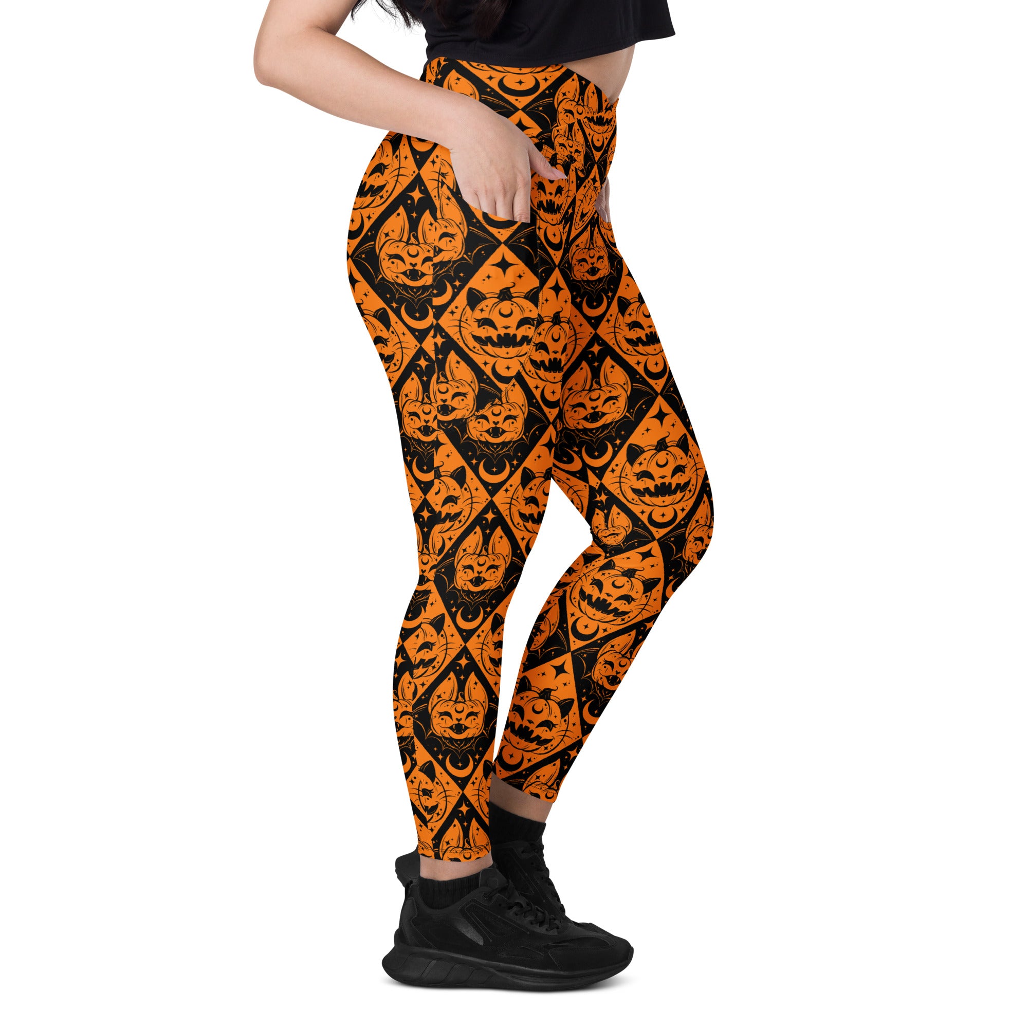 Halloween cat and pumpkin crossover leggings with pockets by Printful, featuring all-over spooky print on white background.