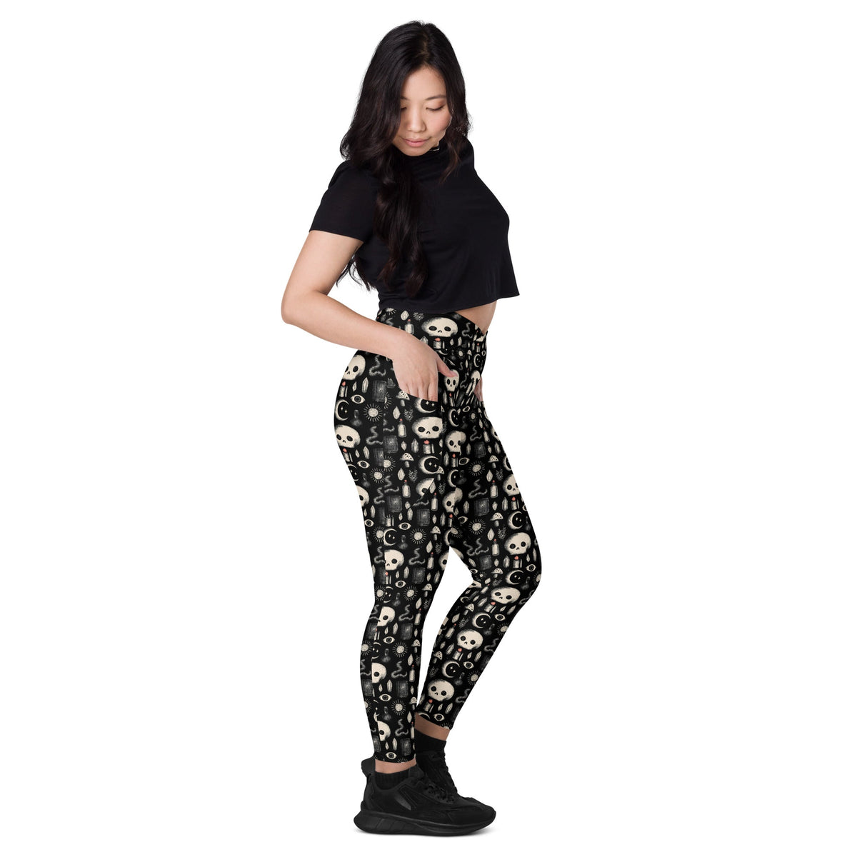 Dark occult crossover leggings with pockets by Printful featuring an all-over white and black mystical print design.