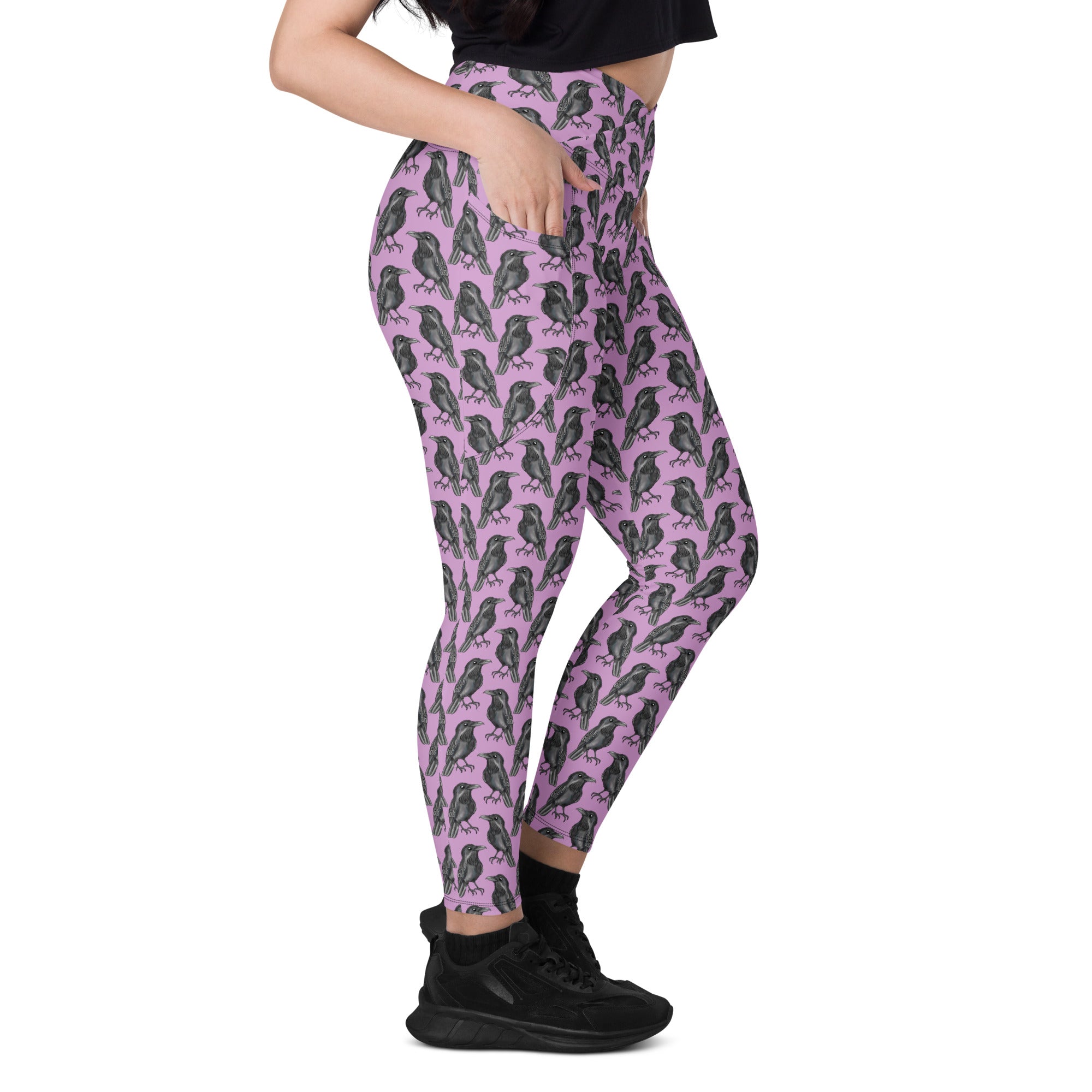 Printful Murder of Crows crossover leggings with pockets featuring an all-over black crow pattern on white recycled fabric.