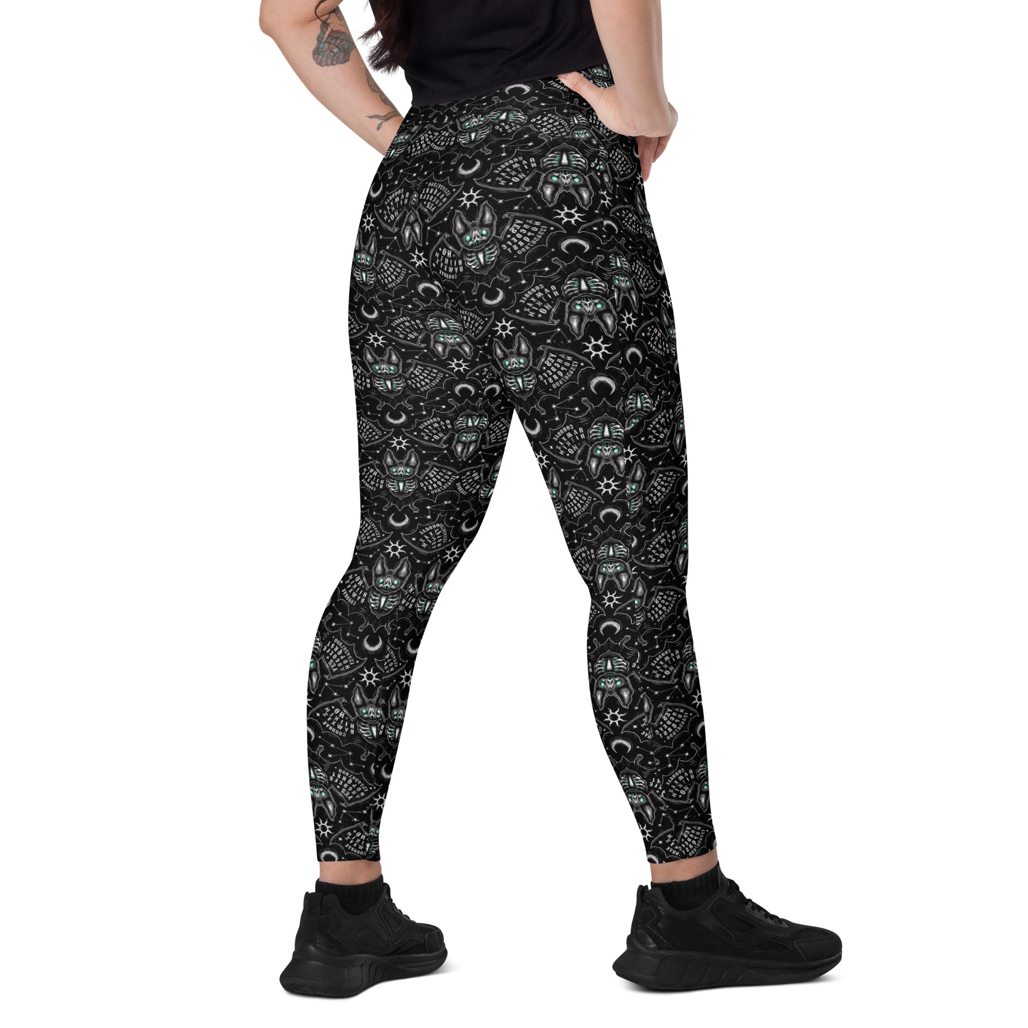 Printful Ouija Bats crossover leggings with pockets featuring all-over bat and Ouija design on white recycled fabric.