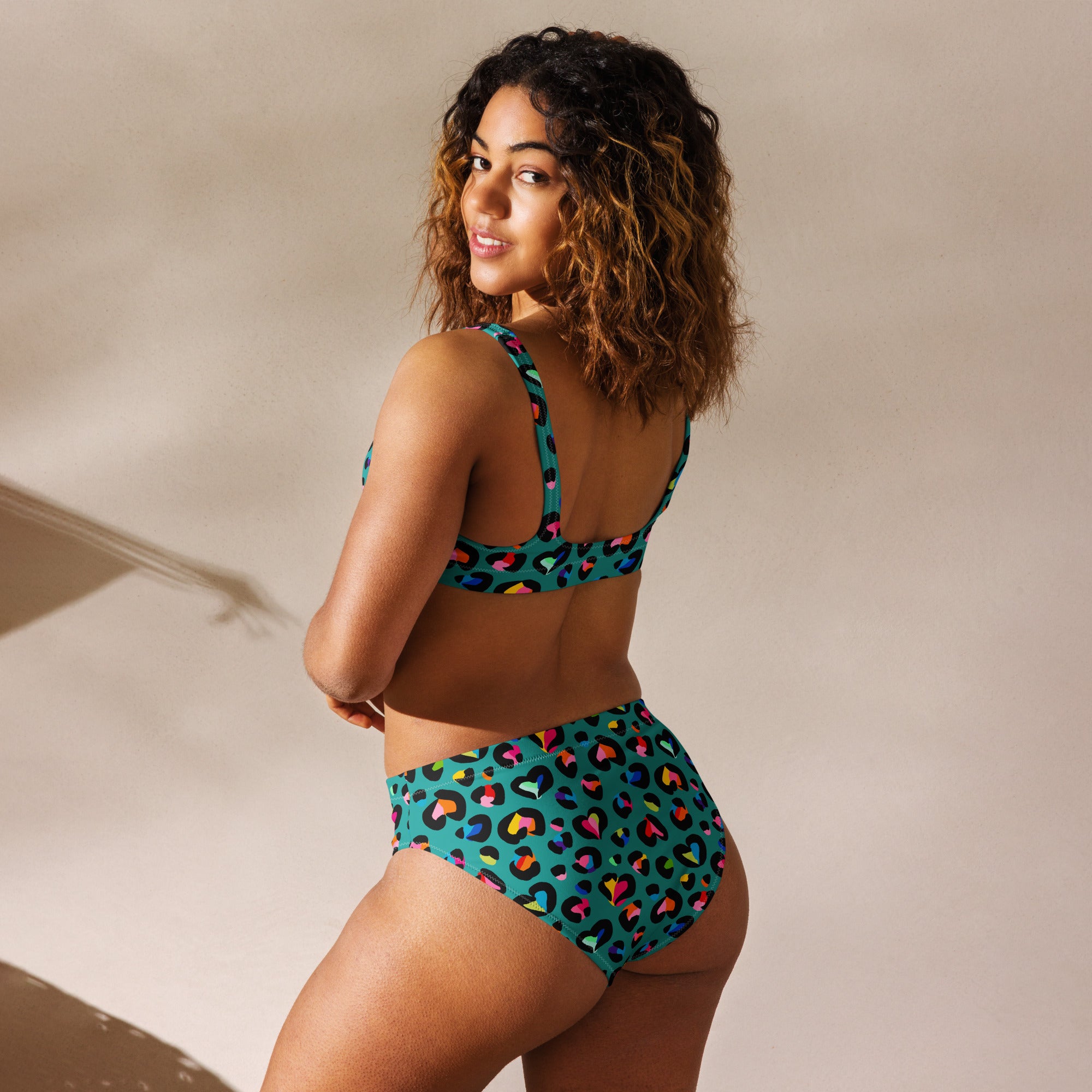 Recycled high-waisted bikini with rainbow leopard print in green, shown from the back on a white background.