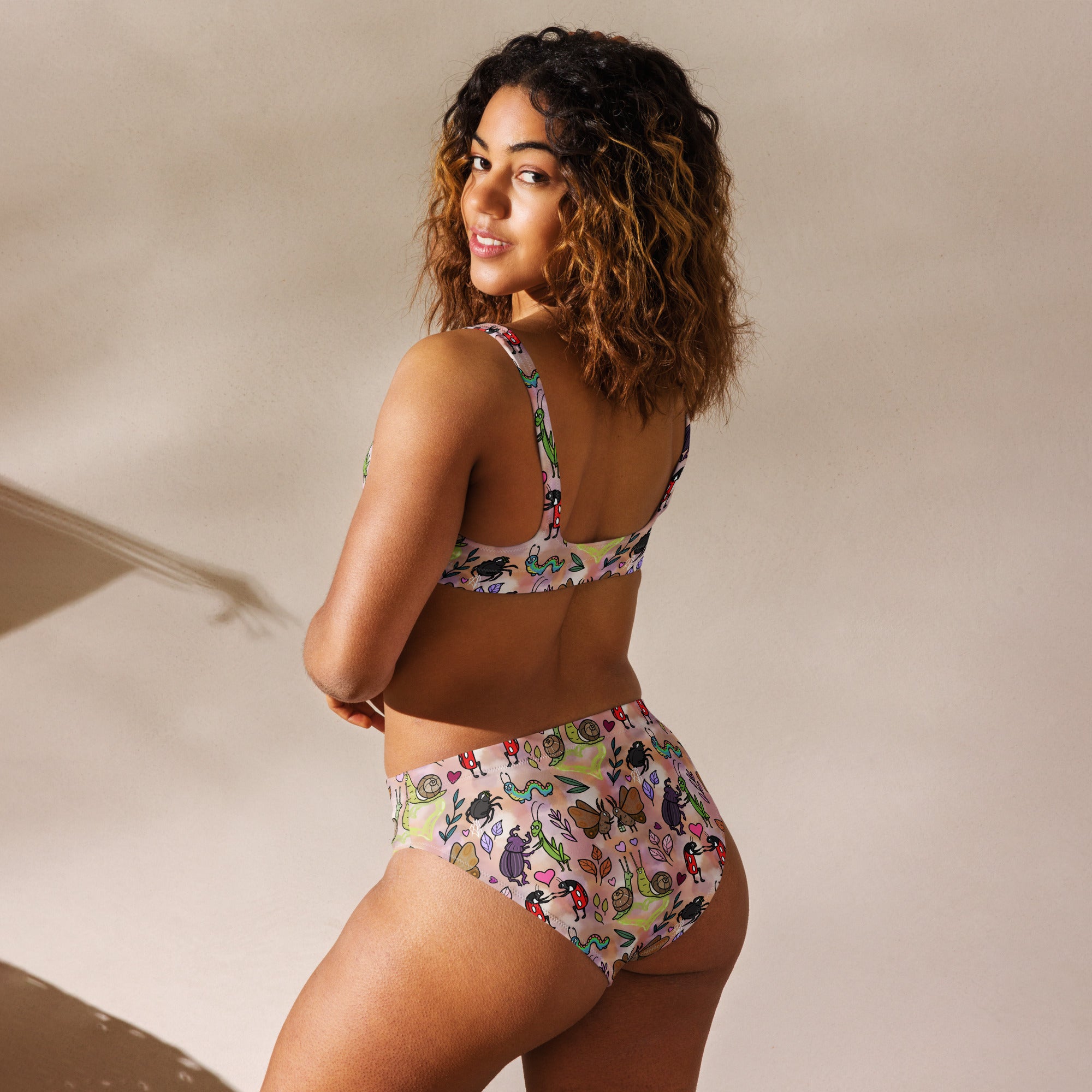 Recycled high-waisted bikini with Love Bugs print in beige, featuring a white back, available in XS to 3XL from Printful.