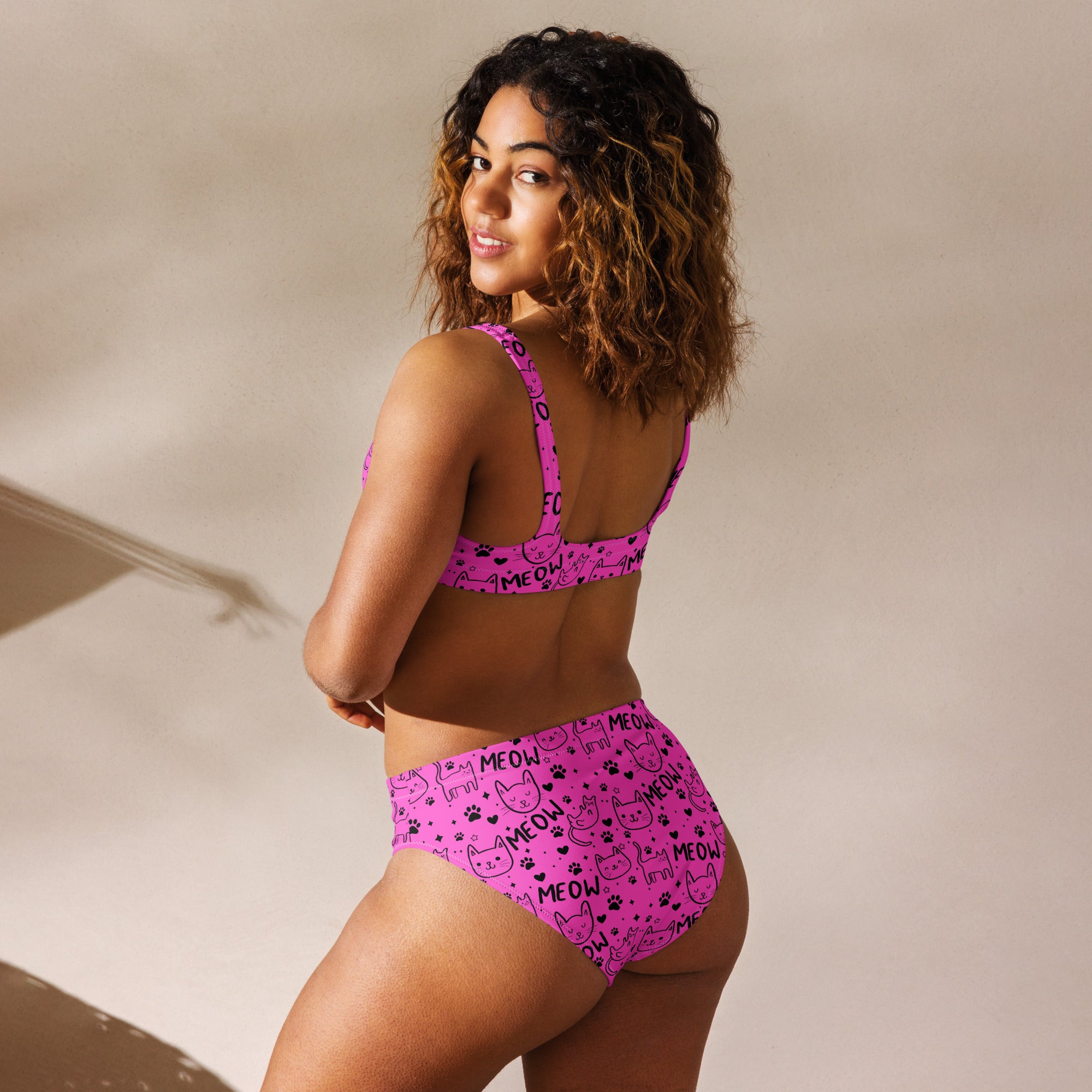 Bright pink recycled high-waisted bikini with a playful Meow cat print, shown from the back with all-over print design.
