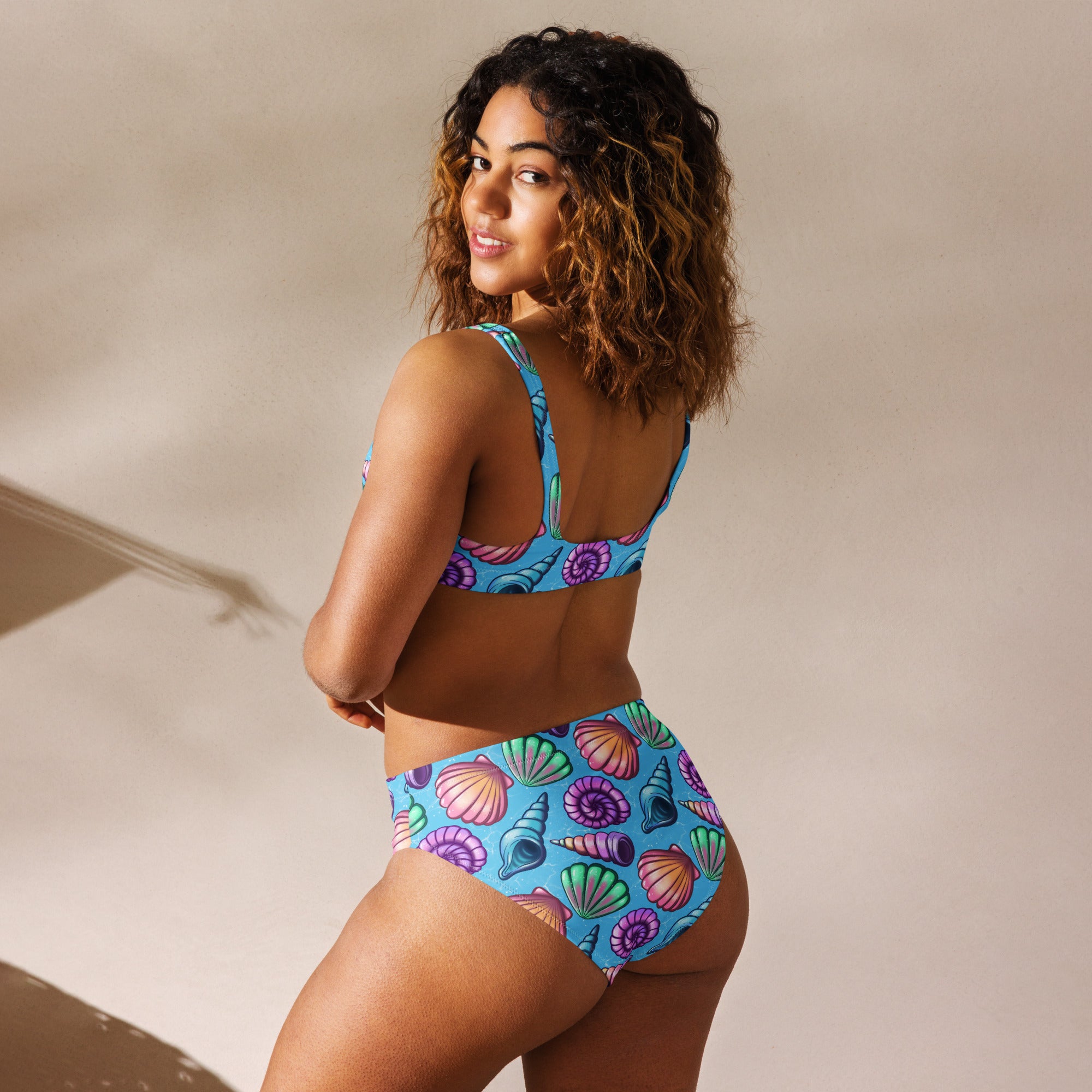 Recycled high-waisted bikini with seashell print by Printful, shown from the back in white with all-over seashell design.
