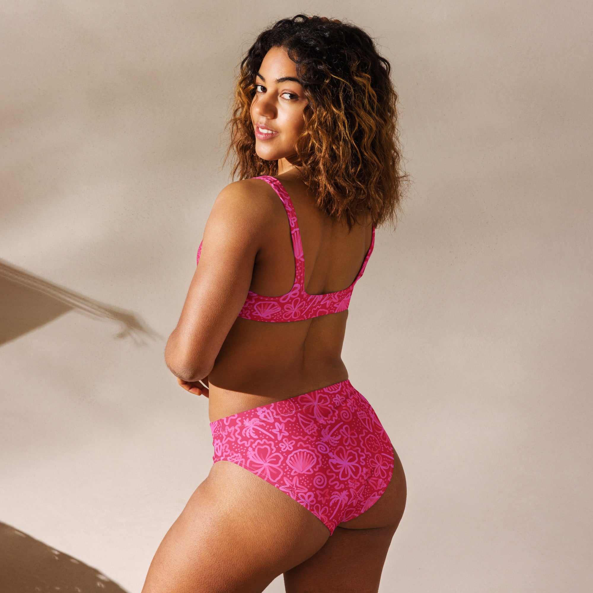 Recycled high-waisted bikini in bright pink with Seaside Delight print, shown from the back on a white background.