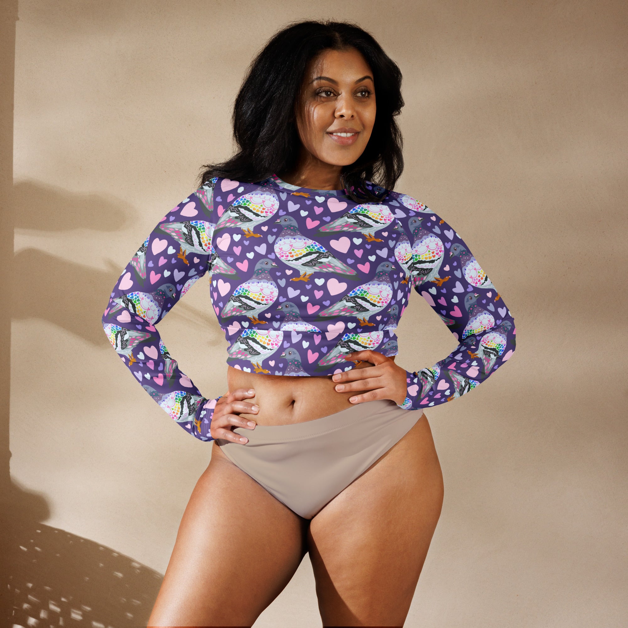 White rash guard crop top with pigeon love print, long sleeves, UPF 50+ sun protection, made by Printful for swimwear.