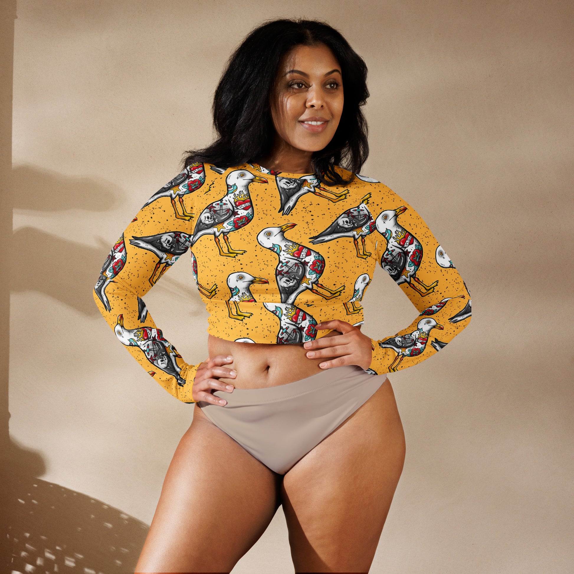 Yellow Nautigul Seagulls recycled long-sleeve crop top rash guard with all-over white seagull print by Printful