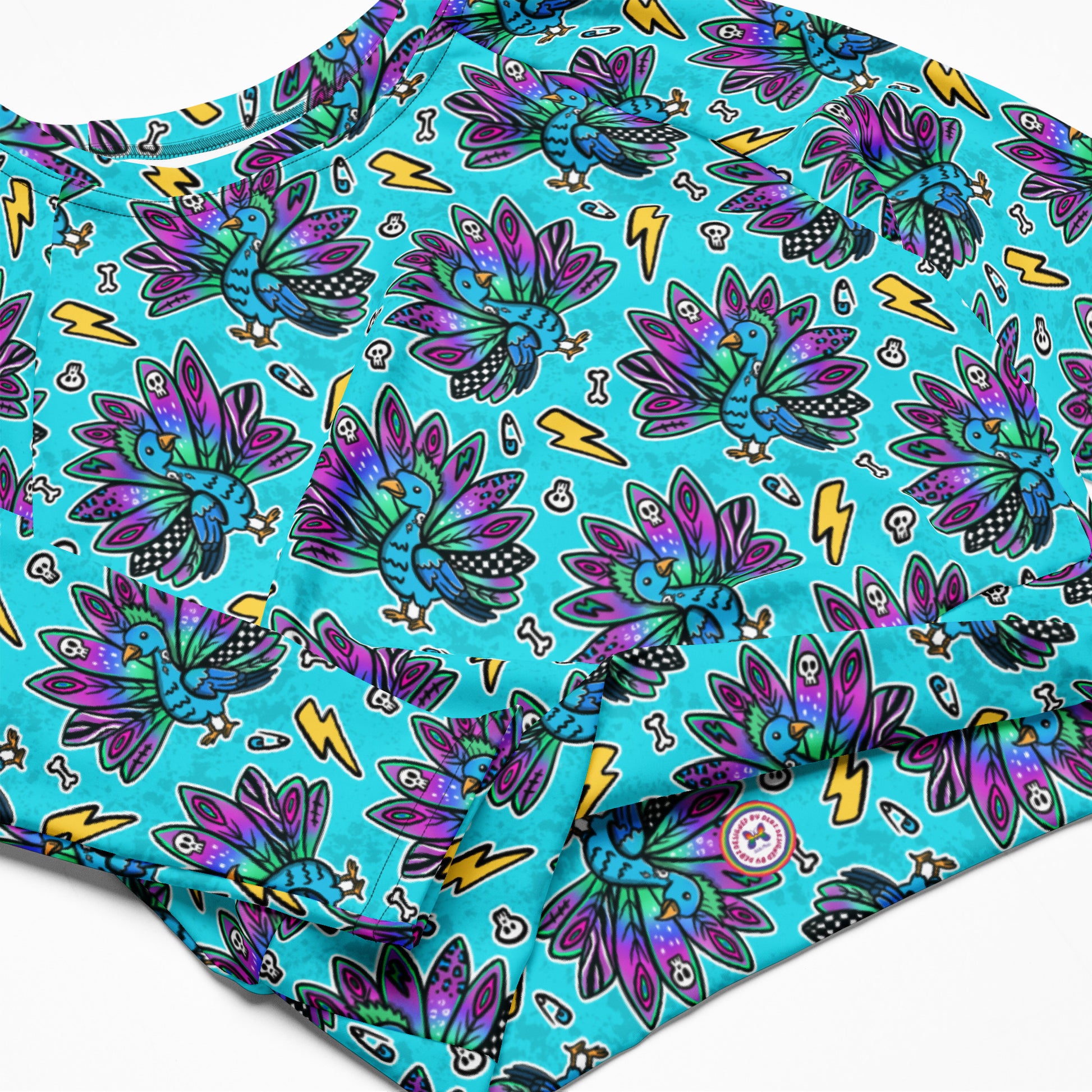 Electric Peacock print rash guard crop top by Printful featuring long sleeves, UPF 50+ sun protection, made from recycled materials.
