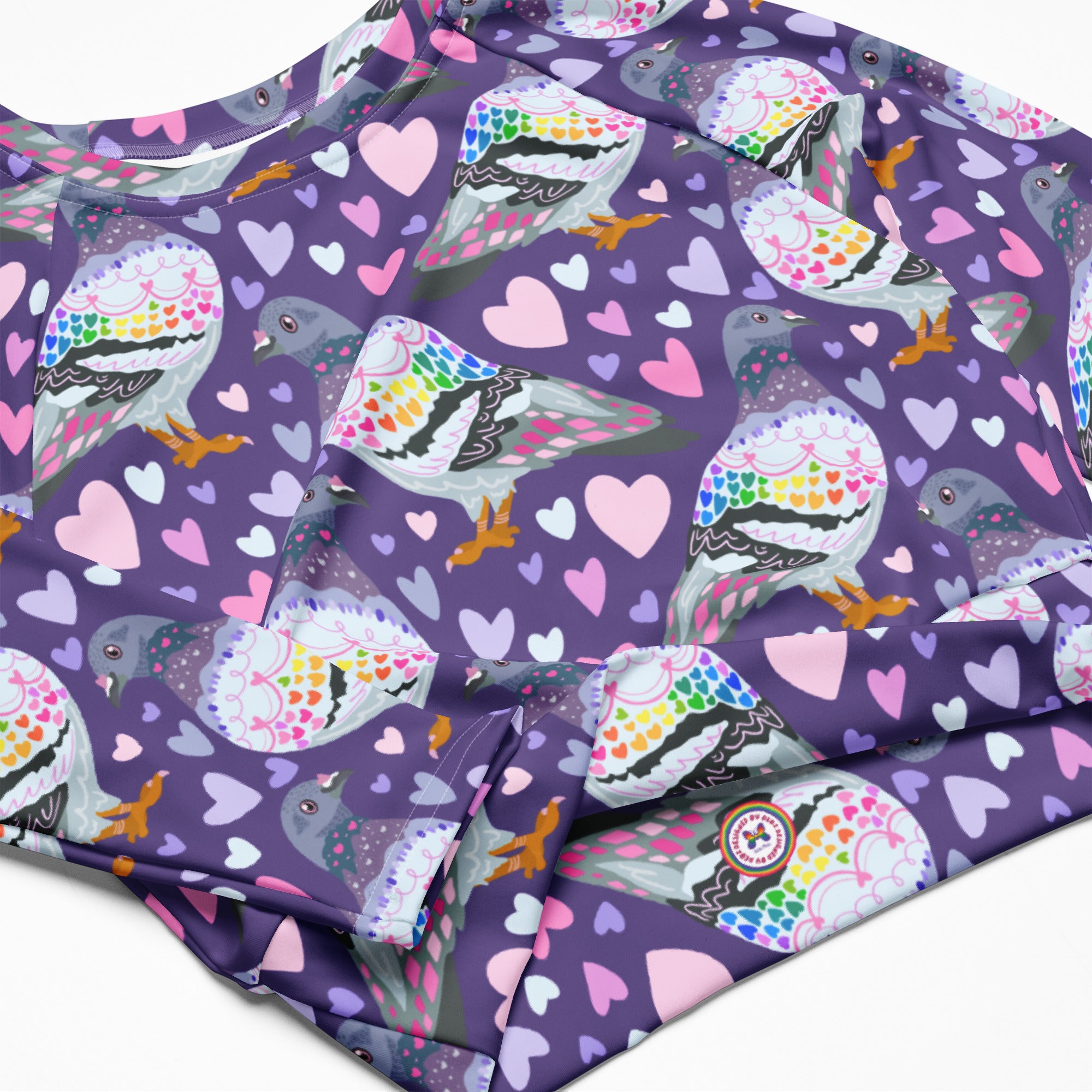 White rash guard crop top with pigeon love print, long sleeves, UPF 50+, made from recycled materials by Printful in Latvia.