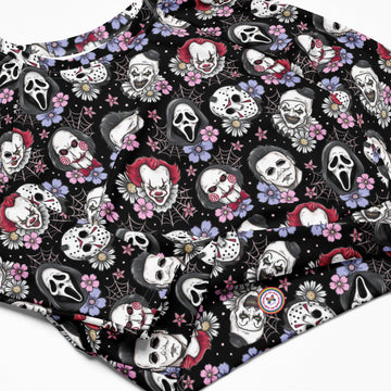 Black horror characters printed long-sleeve crop top rash guard by Printful, featuring all-over spooky design on a white background.