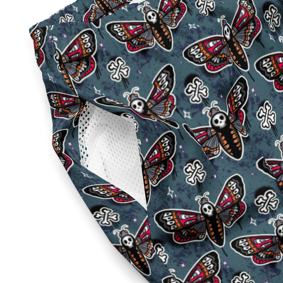 Recycled teal skull moth print swim trunks from Printful with all-over teal and white design, suitable for swimming and beachwear.