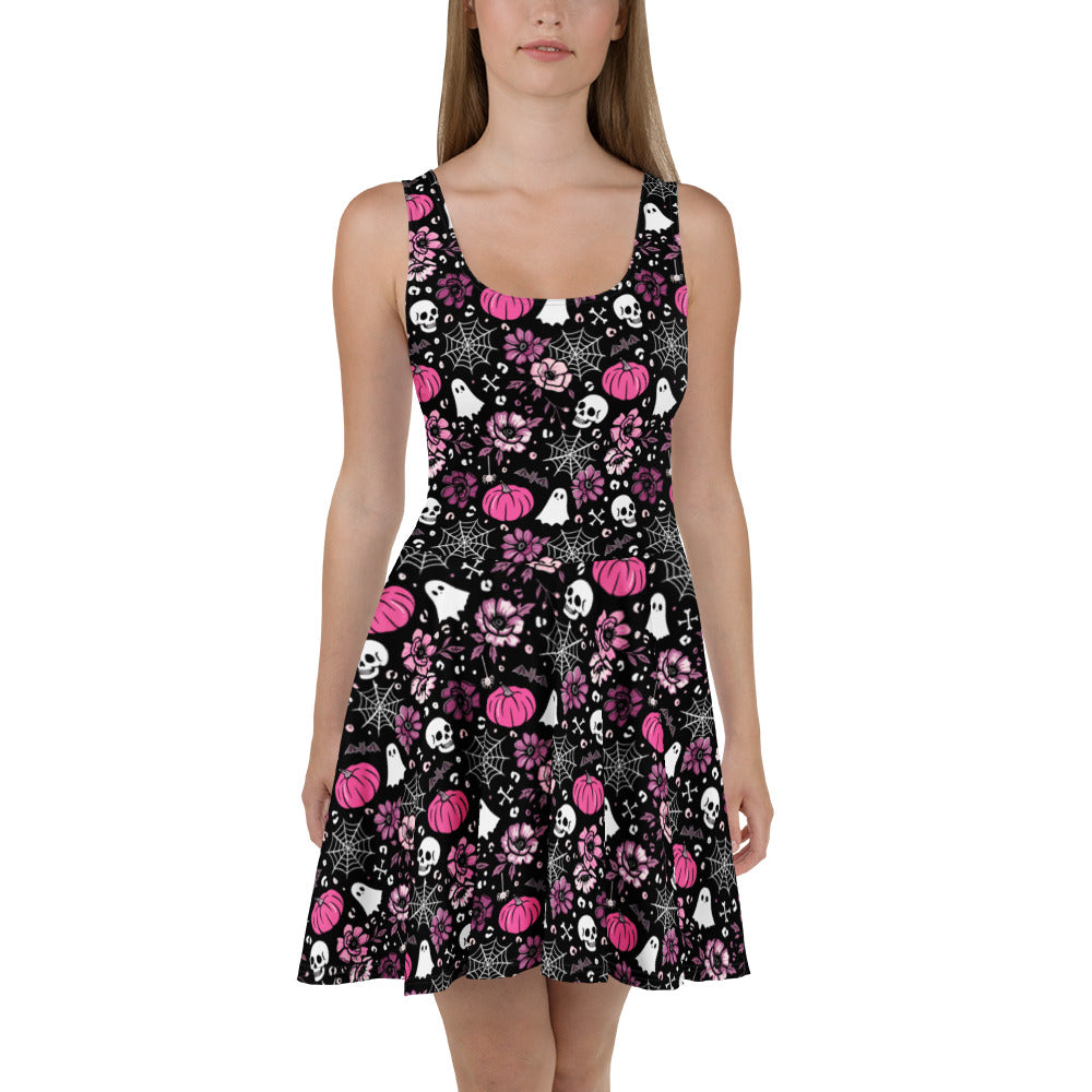 Pink Halloween-themed skater dress by Printful with all-over spooky print, made from recycled fabric, front view.