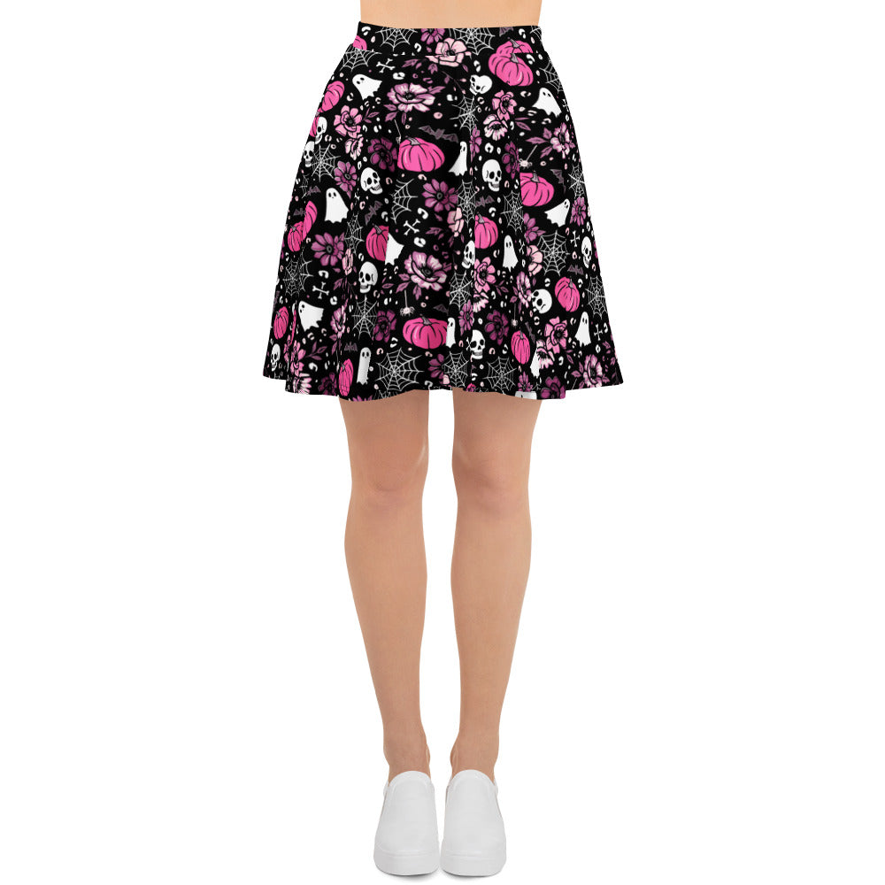 Pink Halloween-themed swim skater skirt with all-over print and UPF 50+ from Printful, shown from the front.