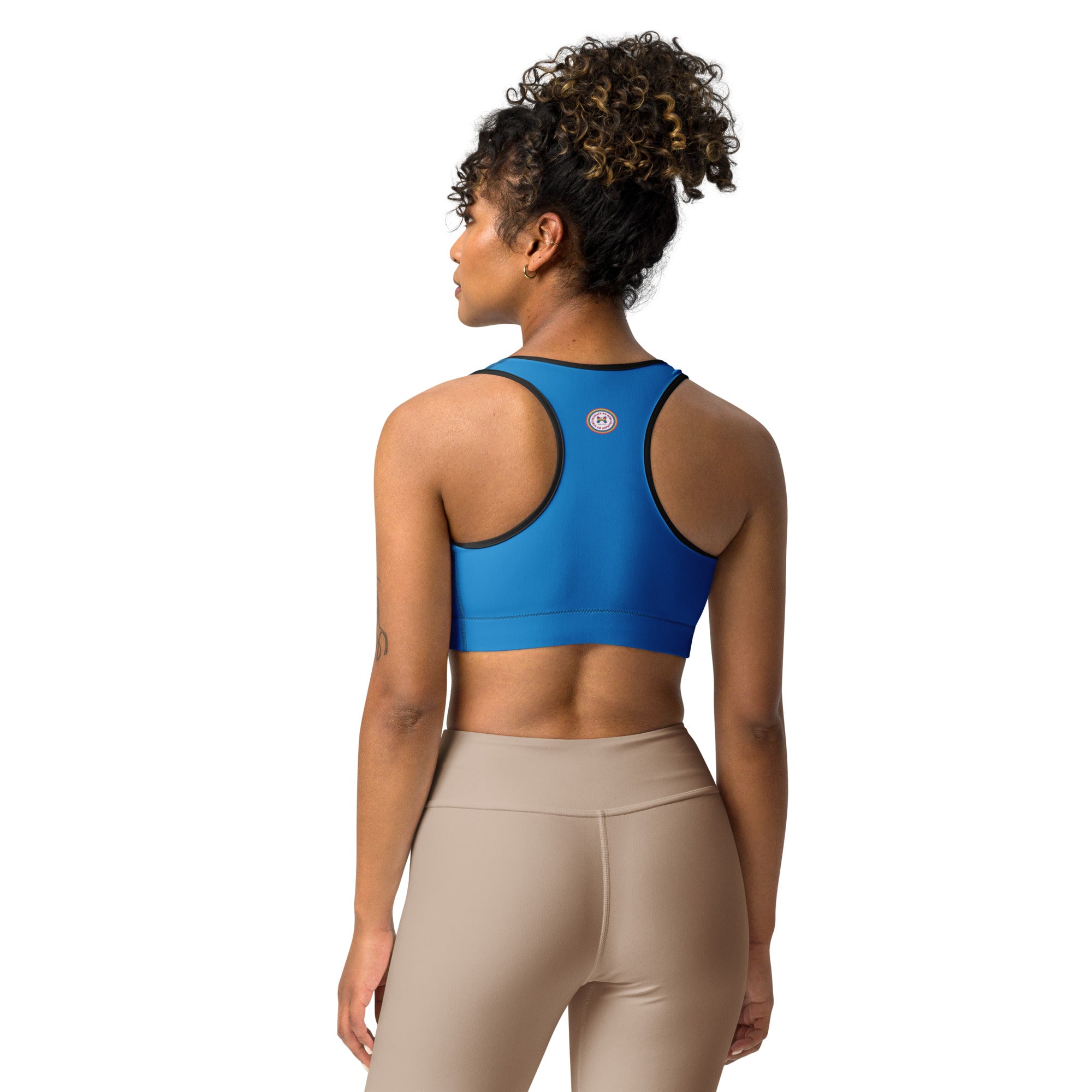 Printful blue sports bra with black binding, all-over print, shown from the back, available in XS to 2XL sizes.