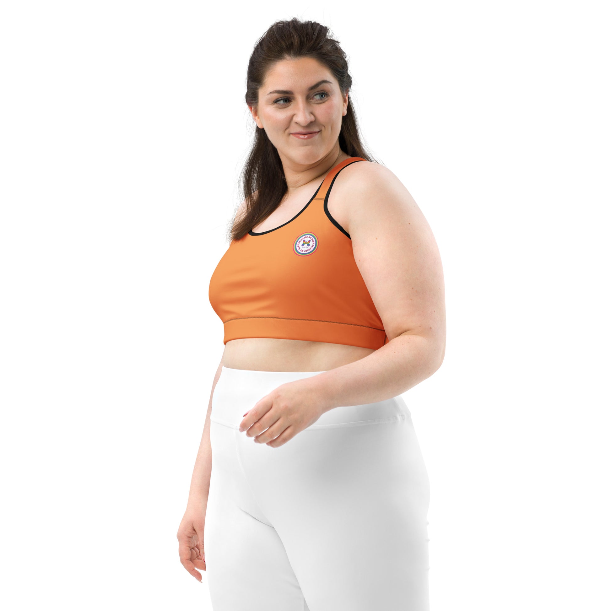 Black all-over-print sports bra by Printful with orange logo, black or white binding, displayed from the front.