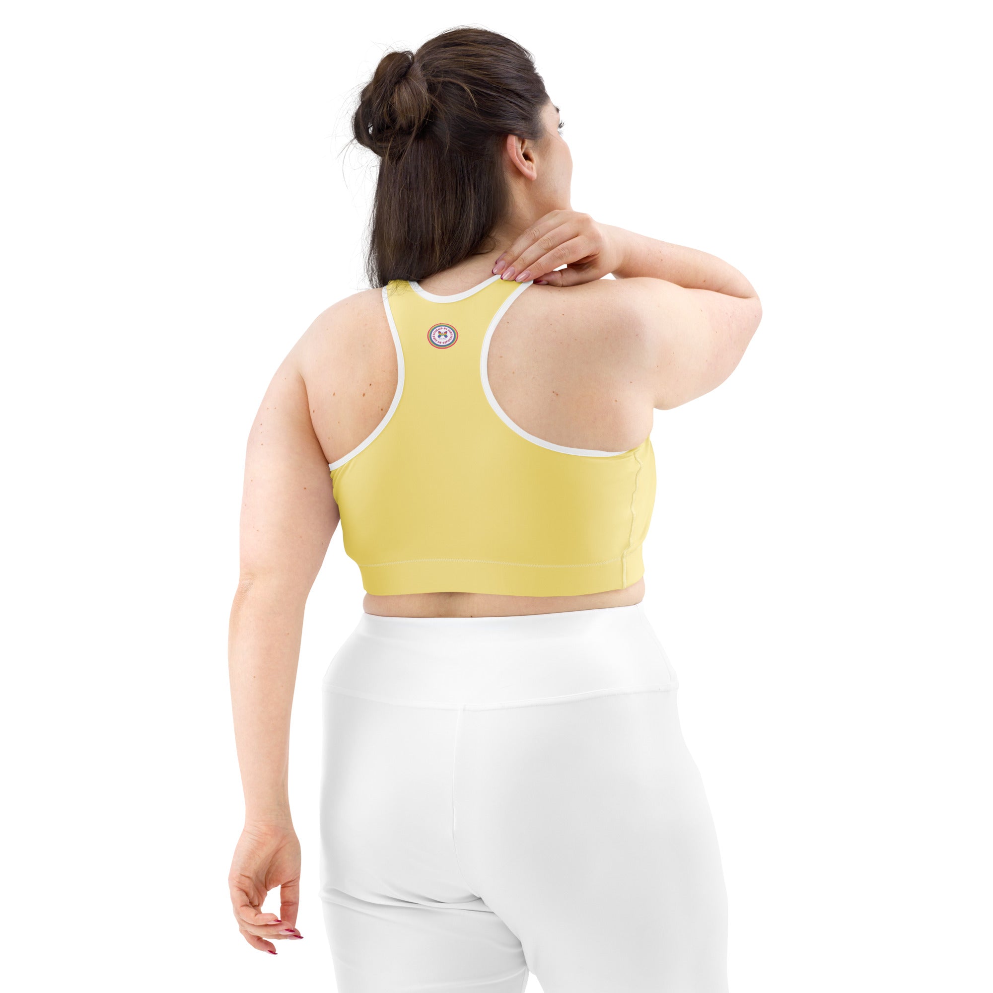White Printful sports bra with all-over yellow print, black or white binding, shown from the back in size XS-2XL.