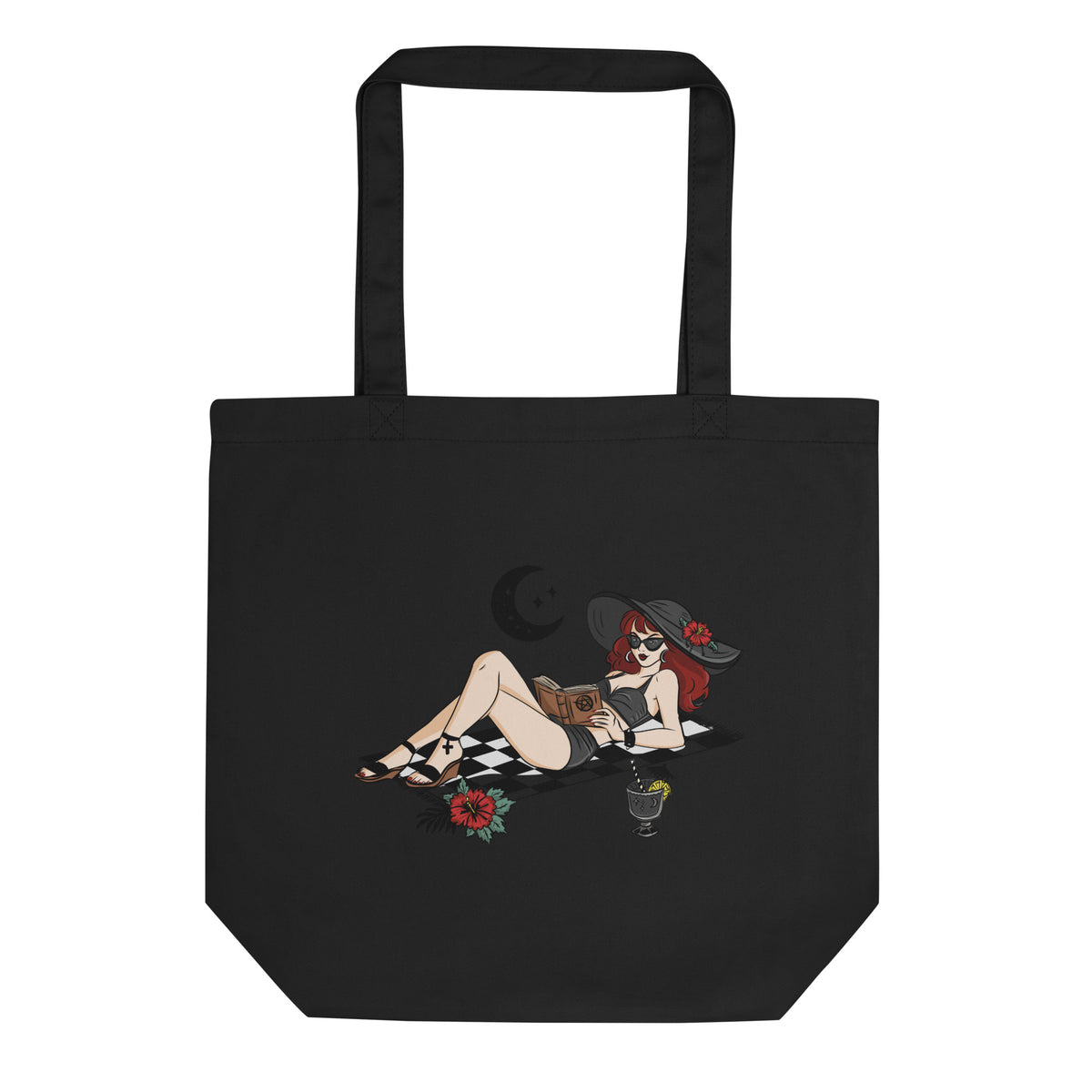A black canvas tote bag with two black handles, featuring a graphic print of a pin-up style woman reclining on a checkered blanket with a red rose and a cocktail glass.