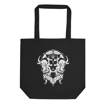 A black canvas tote bag with two black shoulder straps, featuring a large white graphic print of a horned female face with flowing hair on the front, set against a plain white background.