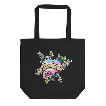A black canvas tote bag with a colorful graphic print on the front. The graphic features a tattoo-style heart pierced by a sword, a pink rose, green leaves, and a banner reading 'FUCK TERFS'.