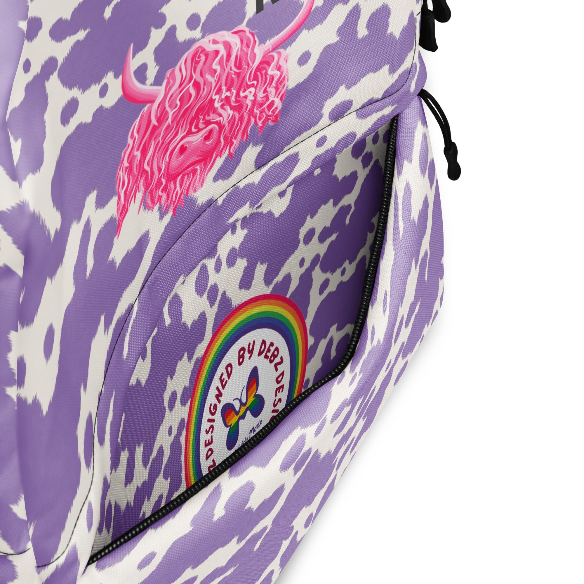 Lilac cow print backpack by Designed By Debz featuring a cute pink cow design and spacious compartments for laptops.